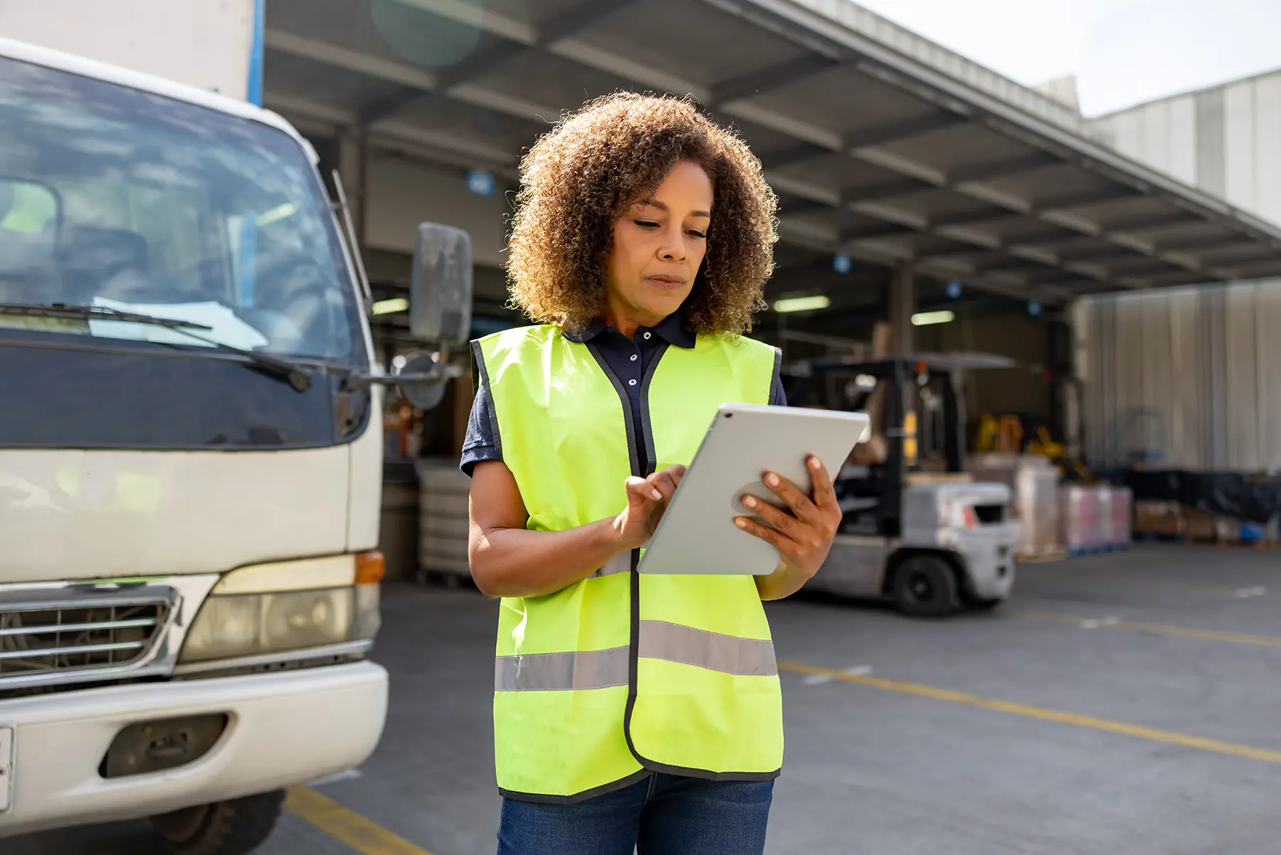 female worker at a factory reviewing HSE documents on an ipad